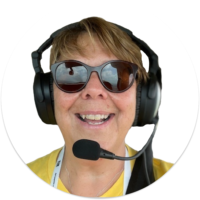 A white woman with sunglasses and a pilot's headset